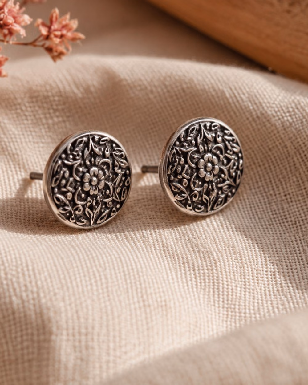 Oxidized silver stud earrings with an engraved round motif.