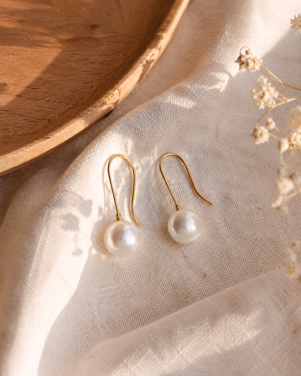 Pearl Drop Earrings with a single pearl on a gold hook.